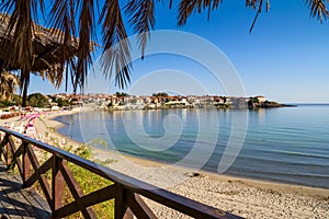 Seaside landscape - view from the cafe to the sandy beach with umbrellas and sun loungers in the town of Sozopol