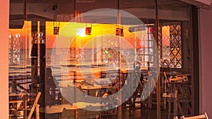 Seaside landscape - view of the coastal cafe with the reflection in glass of sunrise over the sea