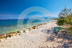 Seaside promenade on Brac island with palm trees and turquoise clear ocean water, Supetar, Brac, Croatia.