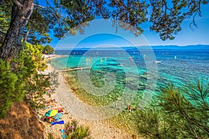 Seaside promenade on Brac island with pine trees and turquoise clear ocean water, Bol, Brac, Croatia