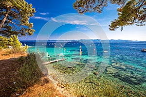 Seaside promenade on Brac island with pine trees and turquoise clear ocean water, Bol, Brac, Croatia