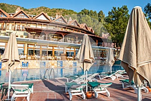 Seaside resort with pool and comfortable lounge chairs with folded sun parasols