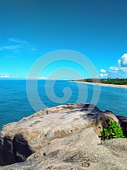 Seaside rock along a vast strech of beach