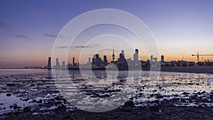 Seaside skyline of Kuwait city from night to day timelapse