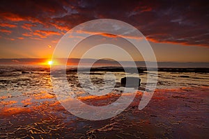 Seaside sunrise and vivid textured rock reflections