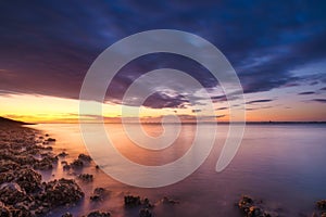 A seaside sunset during sunset. A long exposure photo. Landscape during a bright sundown.