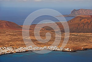 Seaside town of Caleta de Sebo with volcanic mountain background, the main settlement with white houses on La Graciosa, Spain
