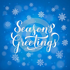 Season s Greetings calligraphy hand lettering on blue background with bokeh and snowflakes. Merry Christmas and Happy New Year cel