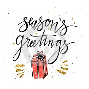 Season`s Greetings card with christmas present, gold glitter elements. Hand lettering calligraphic inscription by brush for Chris