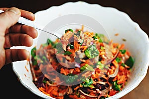 Season salad with carrot, lambâ€™s lettuce and onion in a white bowl