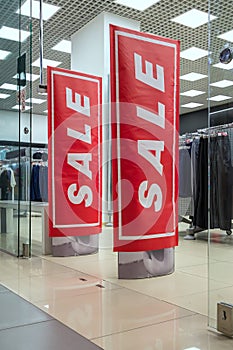 Season sale, black friday and shopping concept. Anti-theft sensor gates at the entrance to the clothing store with red sale sign.