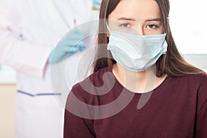 Seasonal adolescent vaccination, nurse giving vaccine injection to teenage girl in hospital, health care, disease prevention