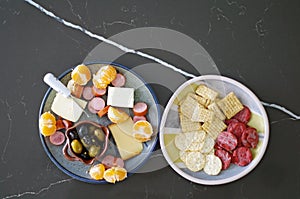 Seasonal appetizer platter with olives, cheese, meat and oranges