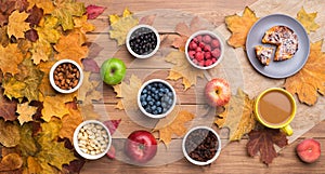 Seasonal autumn background. Frame of maple leaves and a cake, berries, raisins, apples, fruits, coffee and nuts over