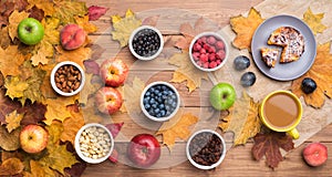 Seasonal autumn background. Frame of maple leaves and a cake, berries, raisins, apples, fruits, coffee and nuts over