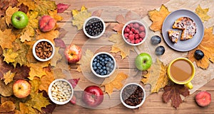 Seasonal autumn background. Frame of maple leaves and a cake, berries, raisins, apples, fruits, coffee and nuts over