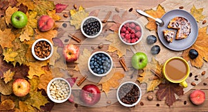 Seasonal autumn background. Frame of maple leaves and a cake, berries, raisins, apples, fruits, coffee and nuts over