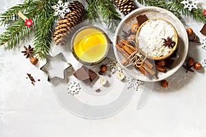 Seasonal baking winter background. Ingredients for Christmas baking - chocolate, spices, nuts, flour and eggs.