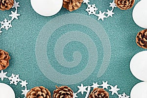 Seasonal Christmas background with white tree baubles, pine cones and star garlad forming border around empty copy space