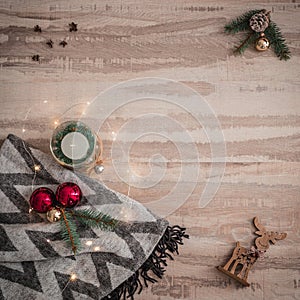 Seasonal Christmas border composed of decorative gifts, deer, candle and scarf, pine branches ornaments over a wooden background