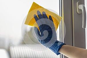 Seasonal cleaning of the house.Washing windows.Gloved hands wash the window