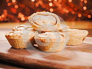 Seasonal delicious mince pie pastry on a wooden table, Glitter warm color background. Popular Christmas season dessert