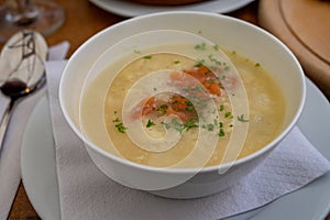 Seasonal dish, white asparagus cream soup with smoked salmon fish