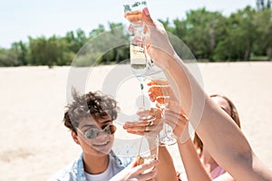 Seasonal feast at beach resort. Group of friends celebrating, resting, having fun on the beach in sunny summer day