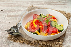 Seasonal fresh vegetable salad with ripe tomatoes, cucumbers, bell peppers