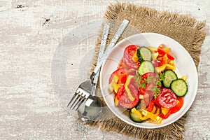 Seasonal fresh vegetable salad with ripe tomatoes, cucumbers, bell peppers