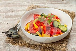 Seasonal fresh vegetable salad with ripe tomatoes, cucumbers, bell peppers