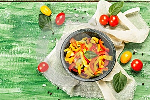 Seasonal fresh vegetable salad. Ripe tomatoes, cucumbers, bell peppers, basil leaves and spices