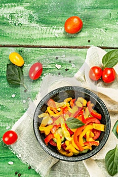 Seasonal fresh vegetable salad. Ripe tomatoes, cucumbers, bell peppers, basil leaves and spices