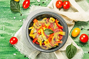 Seasonal fresh vegetable salad. Ripe tomatoes, cucumbers, bell peppers, basil leaves and spices