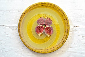 Seasonal fruits dark Sardinian figs on a vintage yellow plate photo