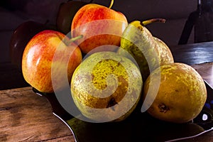 Seasonal fruits. Ripe pears and apples on a black background