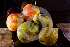 Seasonal fruits. Ripe pears and apples on a black background