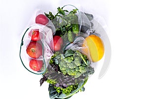 Seasonal fruits and vegetables on white. Raw organic fresh food from market. Zero waste shopping. Reusable grocery bags
