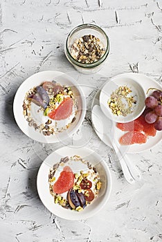 Seasonal healthy breakfast: yoghurt, chocolate granola, pink grapefruit, grapes, pistachios. Top view. Copy space. flat