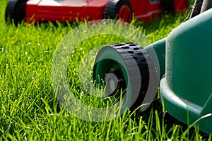 Seasonal maintenance works in garden, lawn movers in action, green grass cutting, lawn care, English lawn