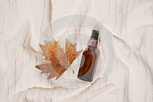 Seasonal Massage essential oil with autumn leaf on white towel, organic cosmetic products, aromatherapy and alternative medicine