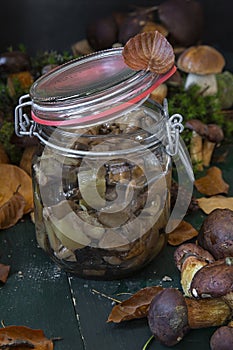 Seasonal mushroom picking. Preparations for the winter, making homemade marinades. Marinated mushrooms in a glass jar standing on