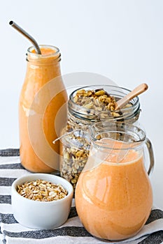 Seasonal pumpkin carrot smoothie drink detox with eco metal drinking straw Glass jar granola muesli oatmeal breakfast