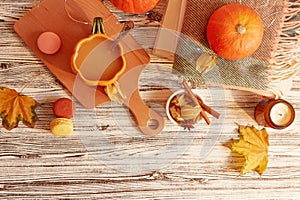 Seasonal pumpkin latte in shape of pumpkin cup among desserts and leaves, Lagom, cozy home