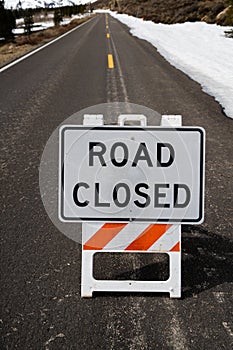 Seasonal Road Closed Sign on Pavement with Snow - Vertival