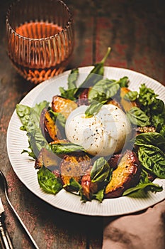 Seasonal salad with burrata cheese and glass of rose wine