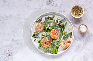 Seasonal salad from prawn shrimp, green asparagus, onion, and seaweed on a plate. Clean healthy eating.
