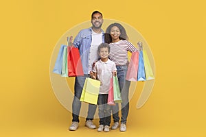 Seasonal Sales. Happy Black Family With Little Son Holding Shopping Bags