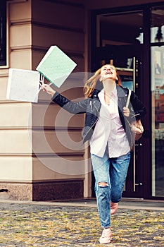 Seasonal sales, shopping, lifestyle concept. Excited shopper girl outside, holding shopping bags. Happy woman after shopping time