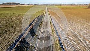 Seasonal Shift: Country Road Flanked by Winter Fields